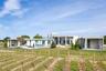 Back of property featuring a lawn, a rural view, and a patio
