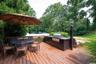 Wooden terrace featuring outdoor dining area and exterior kitchen