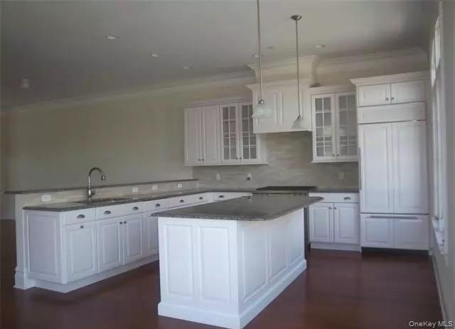 Large center island with breakfast counter... exhaust over Wolf gas cook top/oven combo... granite counters... custom tile back splashes...