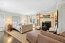 Bedroom with a fireplace, ornamental molding, and wood finished floors