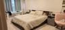Bedroom with light colored carpet, radiator heating unit, and wainscoting