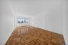 Bright interior space featuring parquet wood flooring and large windows