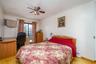 Bedroom featuring wood finished floors, crown molding, an office area, a ceiling fan, and baseboards