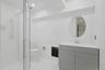 Beautifully renovated, the lower-level full bath features clean contemporary finishes, a spacious walk-in shower, and a contemporary vanity, providing