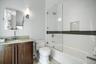 Bathroom with vanity and bath / shower combo with glass door