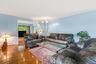 Living room with ornamental molding, hardwood / wood-style flooring, and baseboard heating