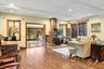 Living room featuring a wood stove, wood finished floors, recessed lighting, a baseboard radiator, and beam ceiling