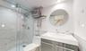 Bathroom featuring an enclosed shower, vanity, and toilet