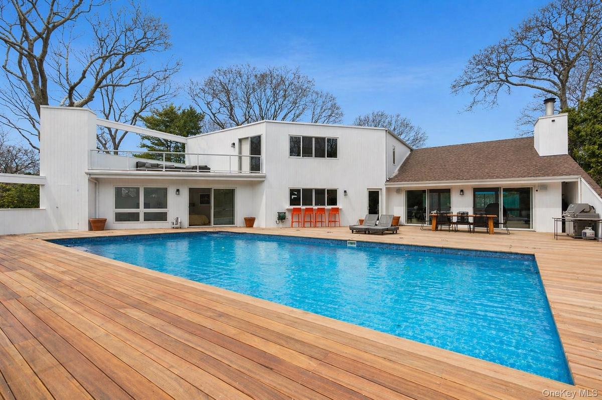 Expansive wood-finish pool deck featuring an in-ground gunite heated swimming pool