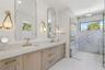 Primary bathroom with dual sinks, custom cabinets and designer lighting