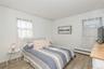 Bedroom with a baseboard heating unit and light wood finished floors