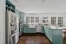 Kitchen featuring green cabinets, stainless steel appliances, a peninsula, french doors, and dark wood-style flooring
