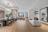 Living area featuring light wood-type flooring, a raised ceiling, and recessed lighting