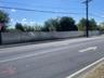View of asphalt street featuring sidewalks and curbs