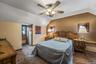 Bedroom with carpet, lofted ceiling, radiator heating unit, and a ceiling fan