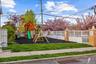 Outdoor play area for small kids featuring a multi-level playset with slides, swings, and rock climbing wall