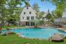 With its picturesque Tudor architecture, sparkling saltwater pool, and beautifully curated landscape, this remarkable property offers a rare blend of
