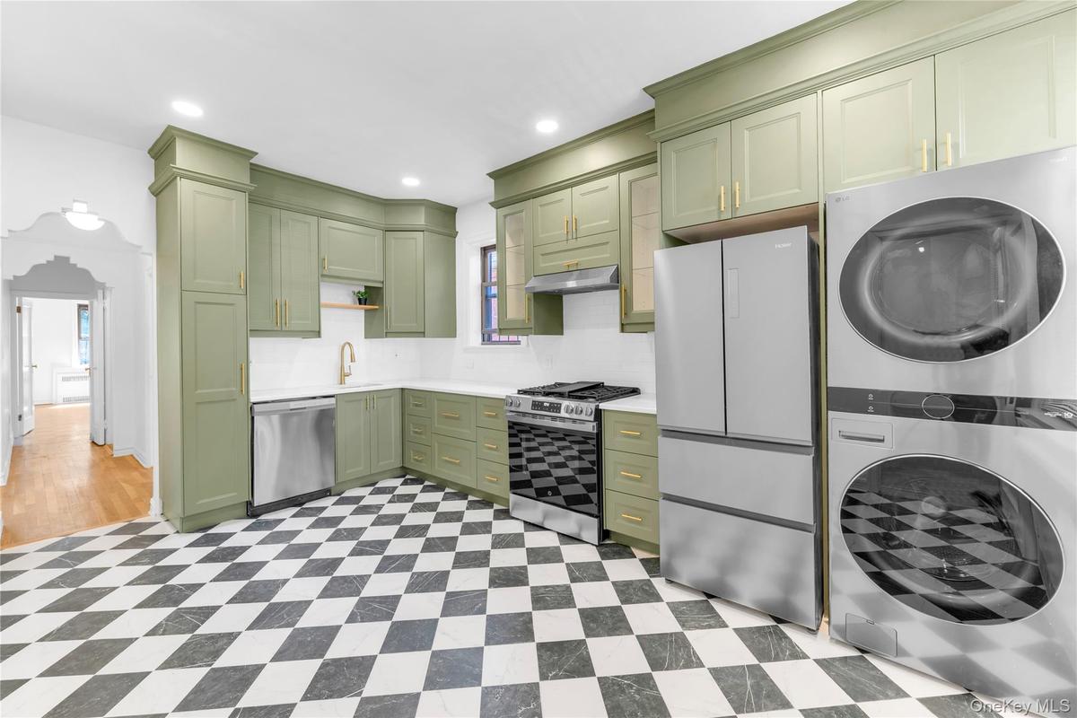 Upper level custom eat-in kitchen with stainless steel appliances and washer / dryer