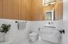 Half bath with marble finish floors, vanity, and tile walls