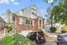 Bungalow-style house featuring brick siding and a garage