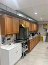 Kitchen with brown cabinetry, recessed lighting, stainless steel microwave, and light stone counters