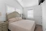 Bedroom with dark wood-type flooring, vaulted ceiling, and ceiling fan