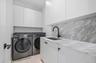 Washroom with washing machine and clothes dryer and cabinet space