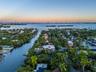 High aerial at sunset showcasing the property's prime location on a deep-water canal leading directly to Biscayne Bay, with Miami Beach, downtown Miam
