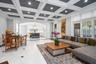 Living area featuring decorative columns, ornamental molding, recessed lighting, arched walkways, and beamed ceiling