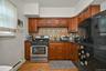 Kitchen with gas range, freestanding refrigerator, tasteful backsplash, a baseboard radiator, and dark stone countertops