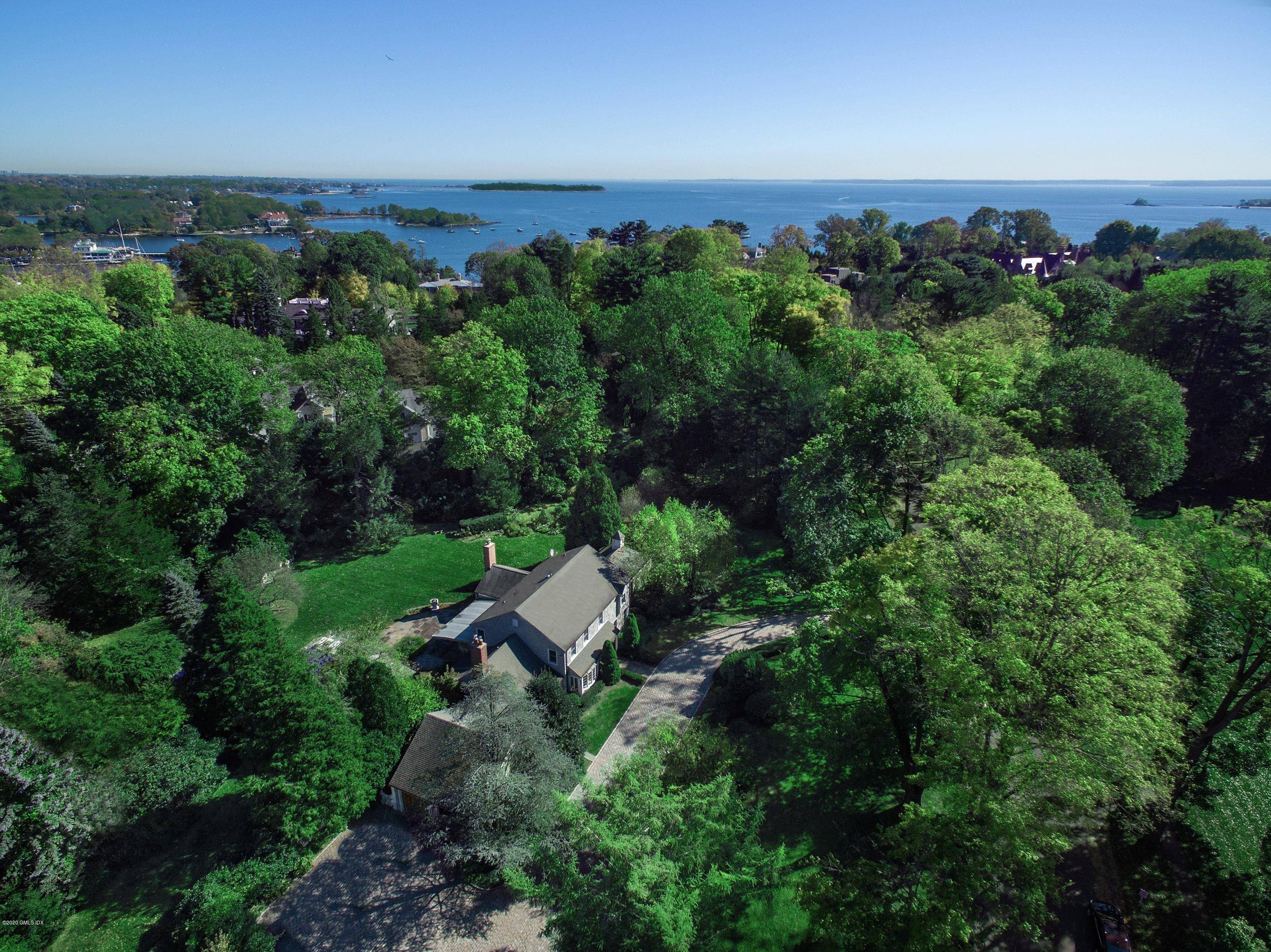 Field Point Circle on an exceptional, nearly 3 acre level property with magnificent trees, elaborate landscaping and amazing privacy with a 24 hour security booth.