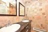 Bathroom featuring vanity, tile walls, backsplash, and baseboard heating