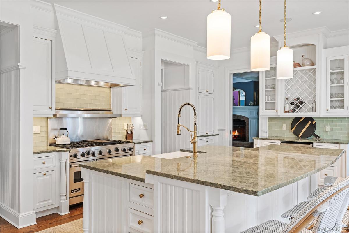 Kitchen with premium stove, a sink, and white cabinetry