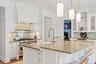 Kitchen with premium stove, a sink, and white cabinetry