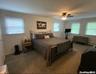 Bedroom featuring a ceiling fan, baseboard heating, and carpet floors