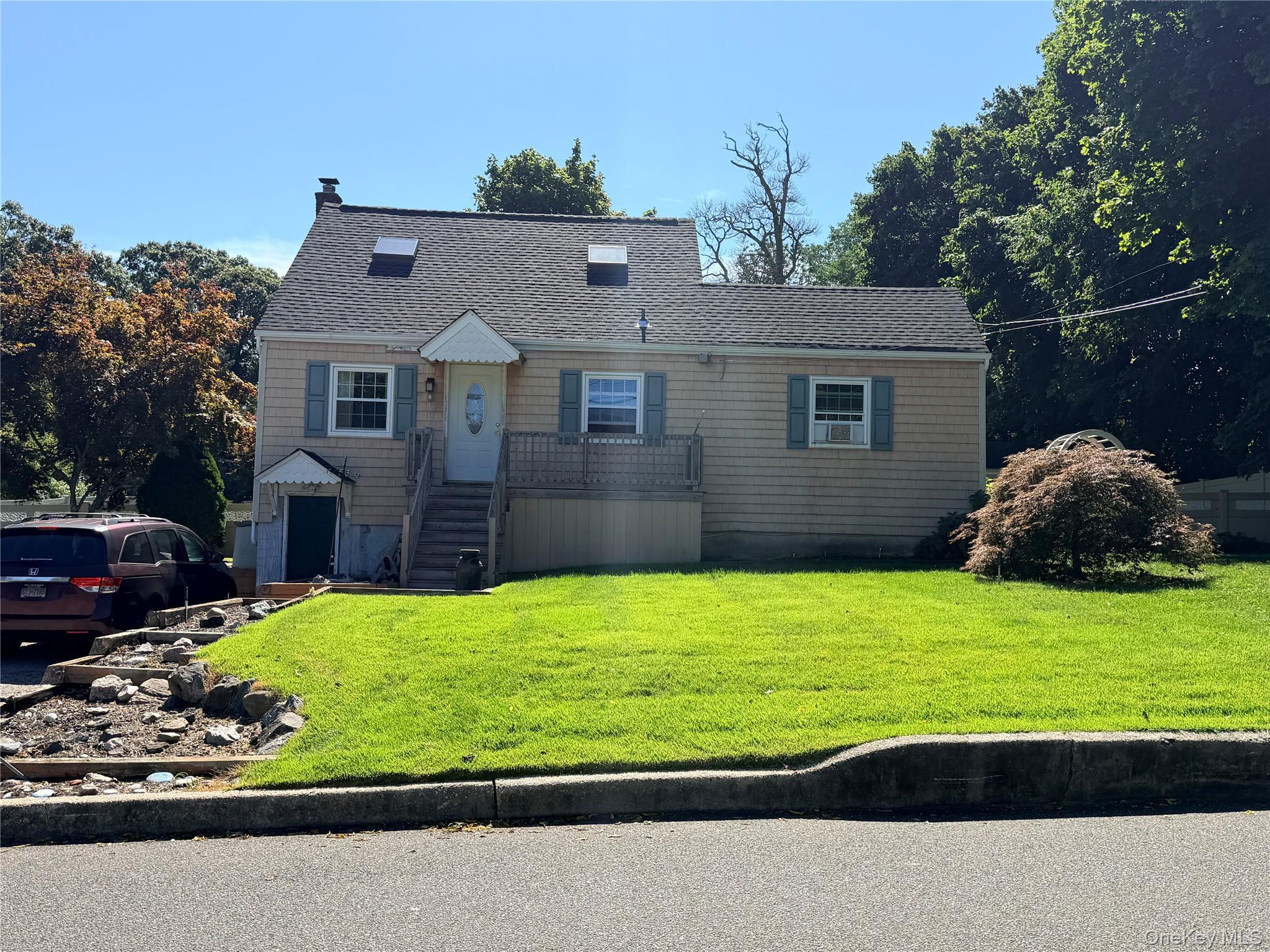 Cape with Shingle siding exterior with a gabled roof and two skylights