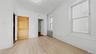 Unfurnished bedroom with radiator heating unit, light wood finished floors, and an ornate ceiling