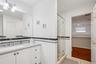 Bathroom featuring vanity, a stall shower, wainscoting, tile walls, and a skylight