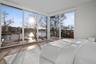 Bedroom featuring access to exterior, a water view, and wood-type flooring