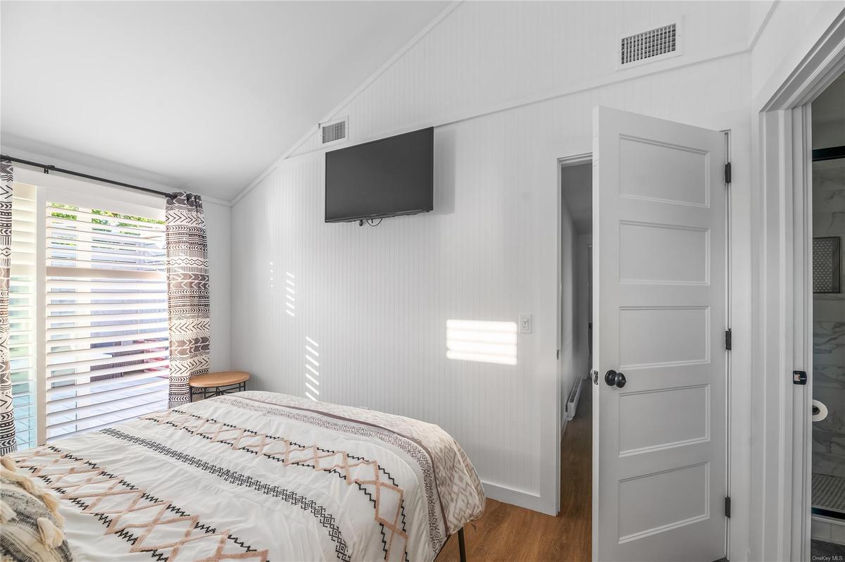 Bedroom with hardwood / wood-style flooring and lofted ceiling