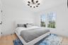 Bedroom featuring an inviting chandelier, wood finished floors, and baseboards