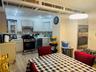 Kitchen featuring stainless steel appliances, light wood-style floors, under cabinet range hood, and light countertops