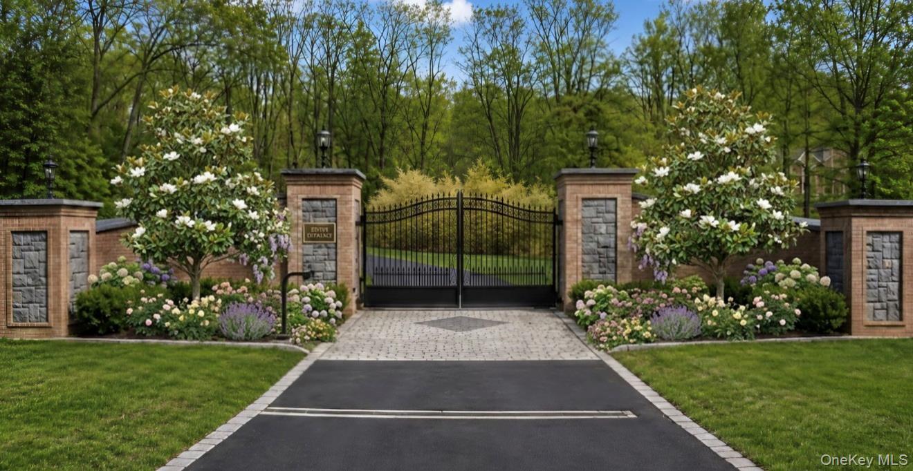 A grand entrance featuring elegant architectural brickwork and impressive 10-foot iron gates creates an immediate sense of luxury and sophistication.