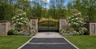 A grand entrance featuring elegant architectural brickwork and impressive 10-foot iron gates creates an immediate sense of luxury and sophistication.
