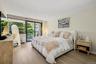 A spacious and beautifully bright bedroom is filled with abundant natural light, creating an airy, peaceful retreat.