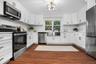 Bright and spacious kitchen with custom shaker cabinets, gold hardware, and a farmhouse sink for a perfect blend of elegance and function.