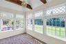Sunroom with imported hexagonal tile flooring, exposed wood ceiling beams, and a crystal chandelier