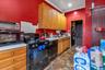 Kitchen with ornamental molding and black appliances