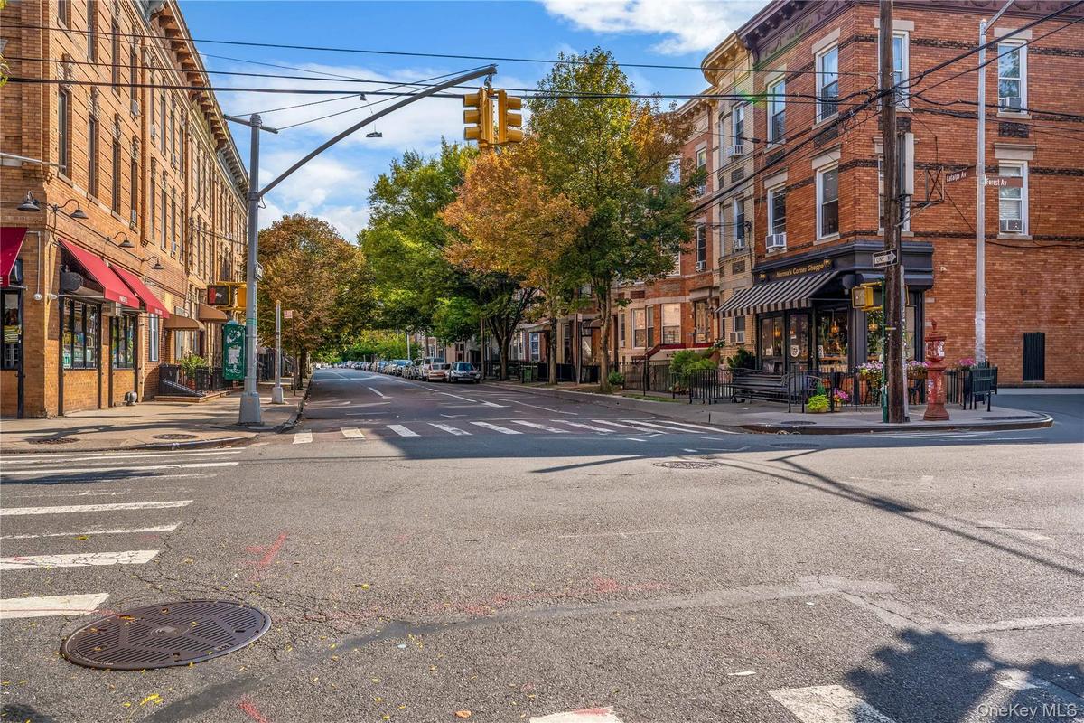 View of asphalt street featuring sidewalks, curbs, and street lighting