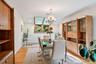 Dining room with light wood-style flooring, vaulted ceiling, a chandelier, recessed lighting, and a baseboard radiator
